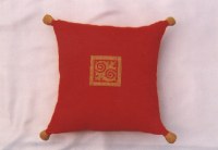 Housse coussin rouge à ponpons dorés